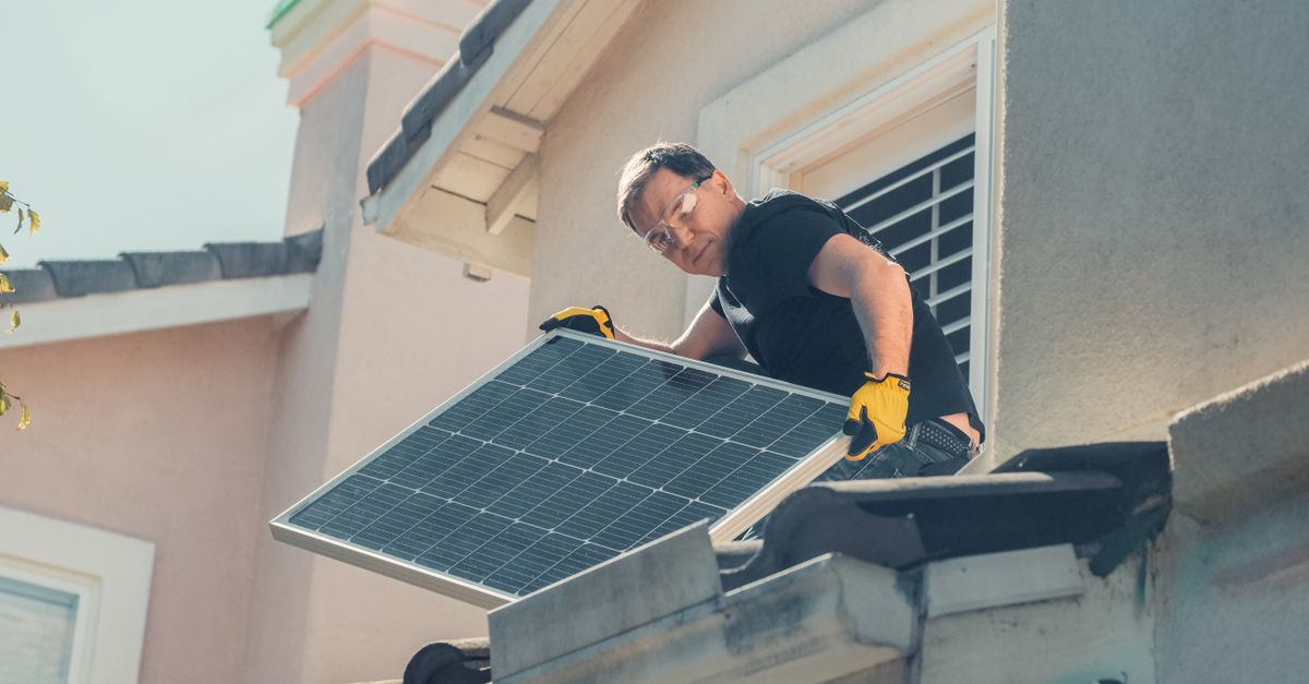 Installateur en train de poser des panneaux photovoltaïques sur une toiture